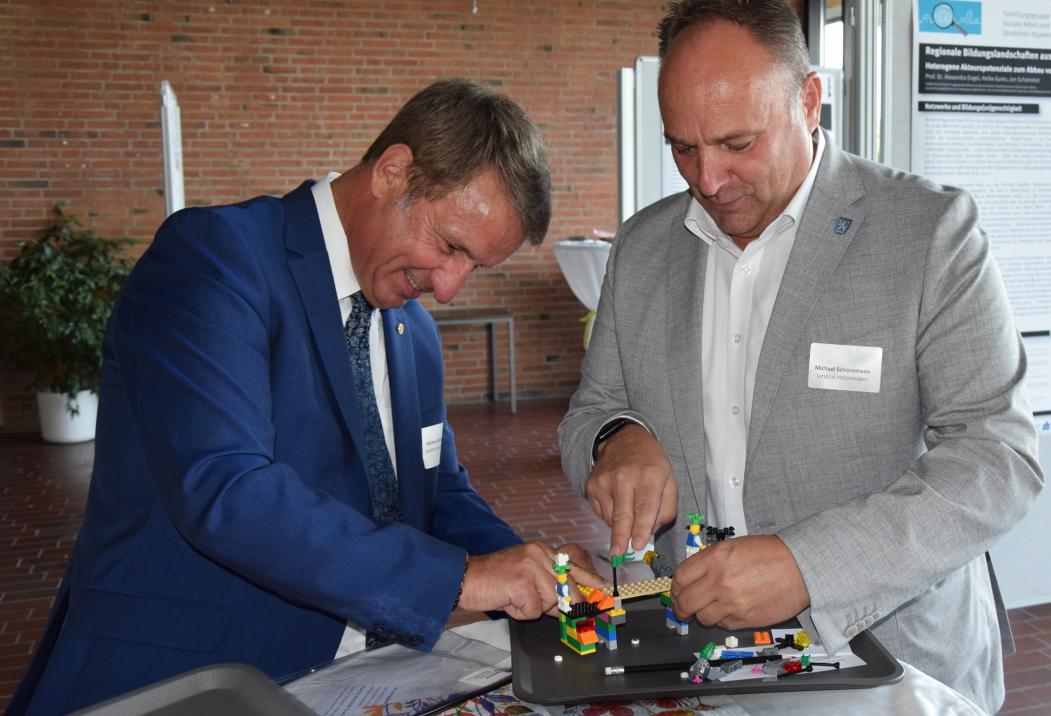 Die Landräte Michael Stickeln (Höxter) und Michael Schünemann (Holzminden) in kreaitver Gemeinschaftsarbeit auf der Jubiläumsfeier des ZZHH.